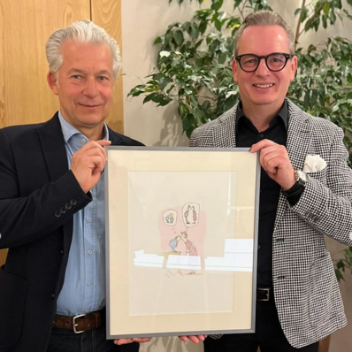 Ralf Thiele und Dr. Peter Ufer mit Karikatur von Axel Bierwolf